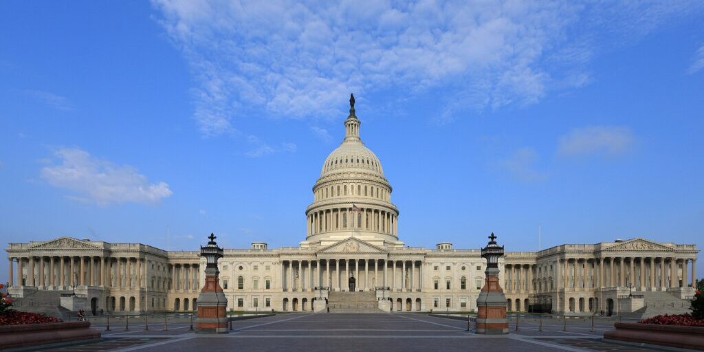 Front facade of the U.S. Capitol building under blue sky with white clouds